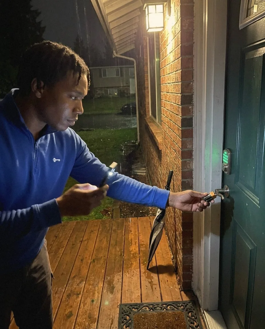 Peak Locksmith technician holding a 9-volt battery to the contacts under a keypad deadbolt at night in Tacoma, WA